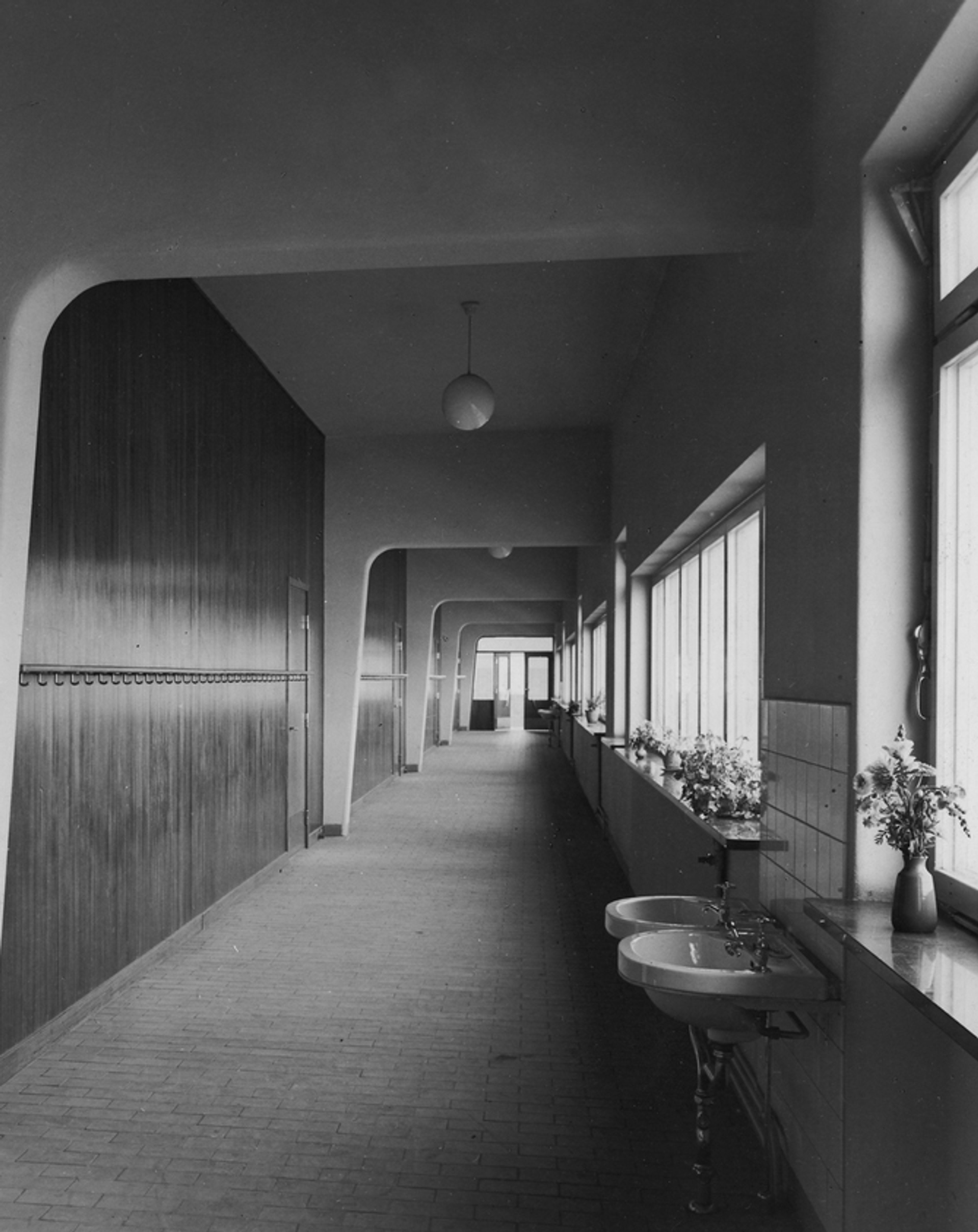Arkivbild i svartvitt som visar korridor i funkisstil i Sannaskolan