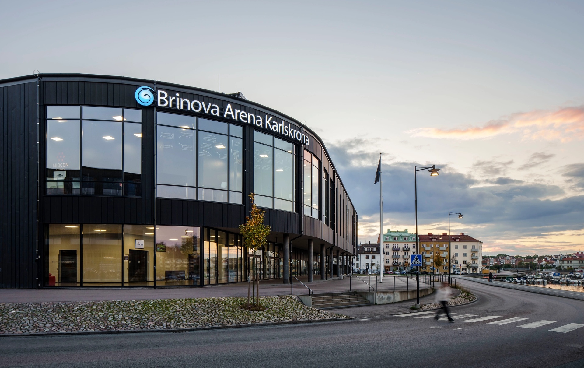 Brinova Arena Karlskrona, exteriör. Rundad fasad mot vattnet.