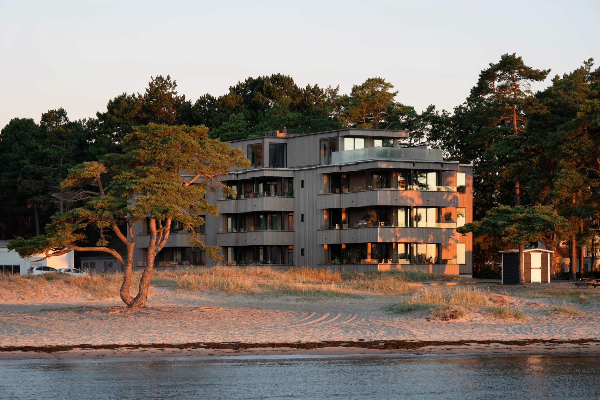 Kvällsbild från havet mot Åhus Seaside Bostäder, precis intill stranden