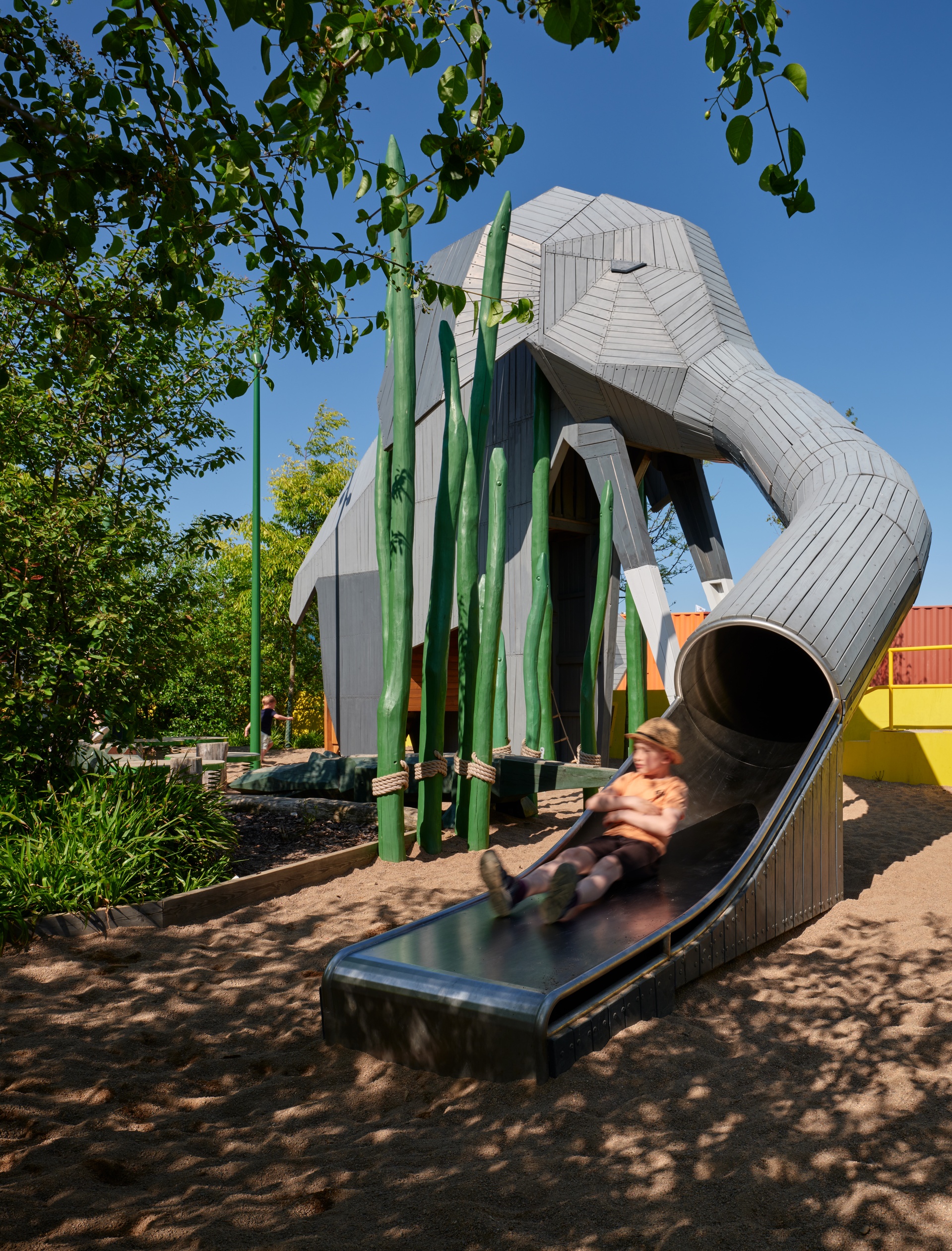 Barn åker rutschkana i elefantsnabel i Djungellekan