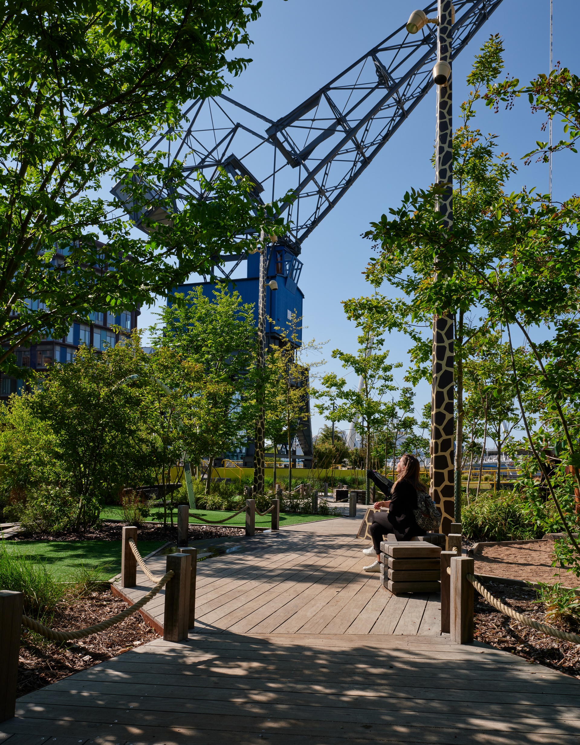 Person sitter på bänk i parken Djungellekan