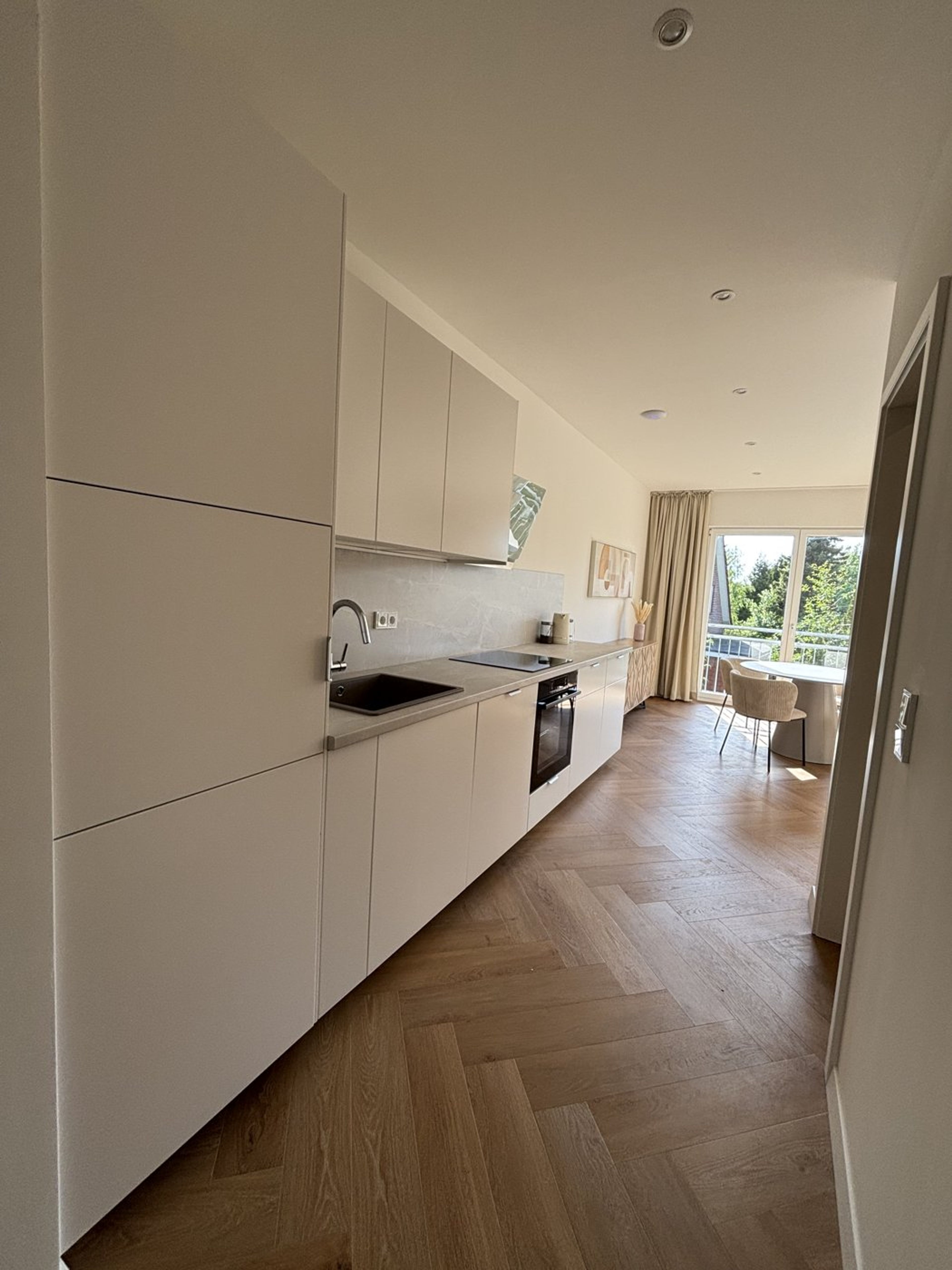 Lange Küchenzeile mit Blick zum Essbereich und Balkon