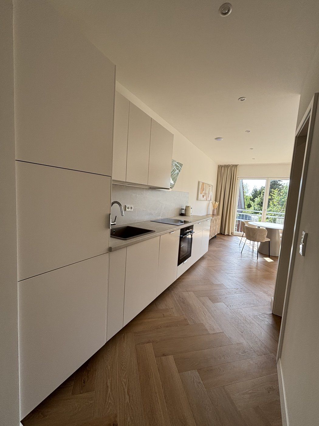Lange Küchenzeile mit Blick zum Essbereich und Balkon