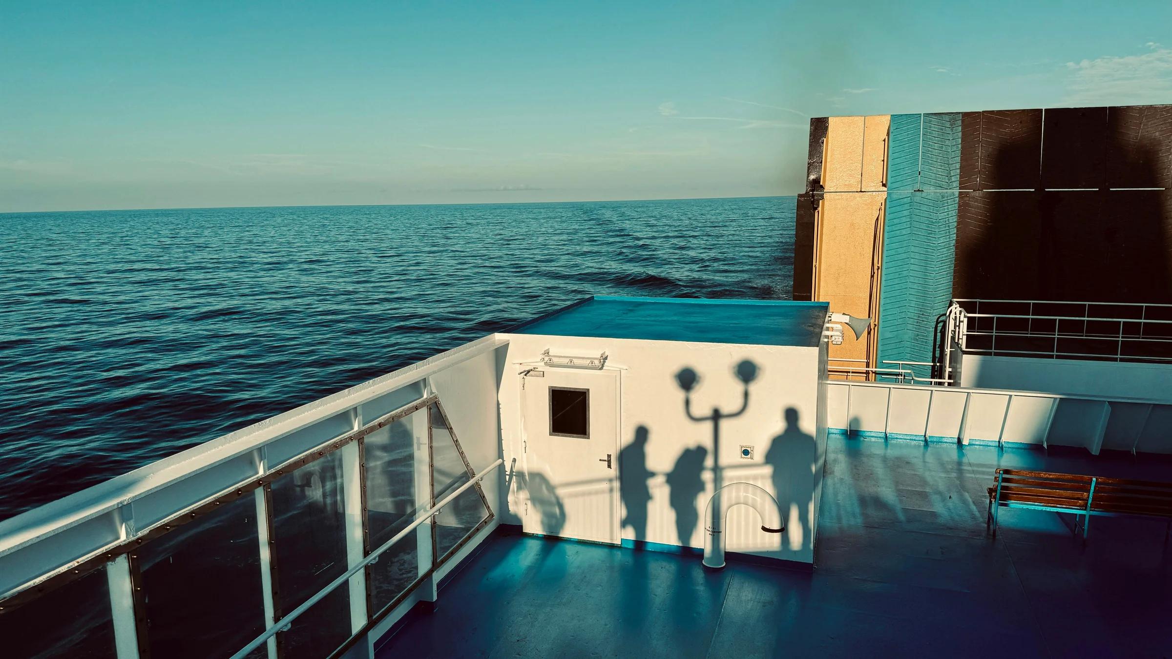 A couple of people standing on the deck of a boat
