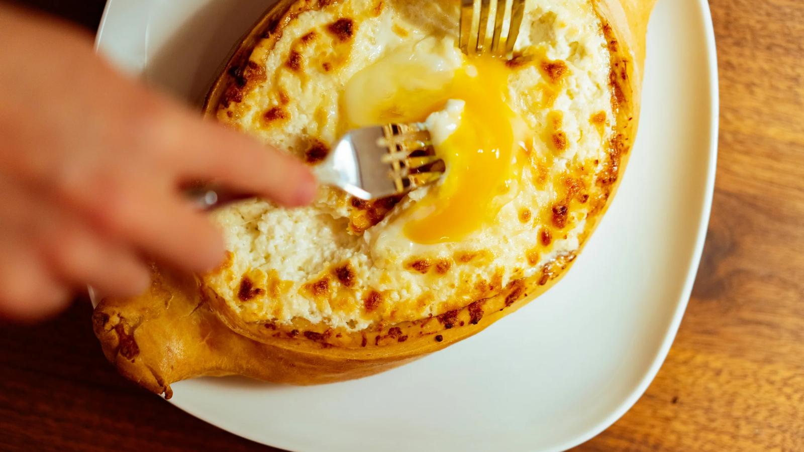a person holding a fork over a plate of food
