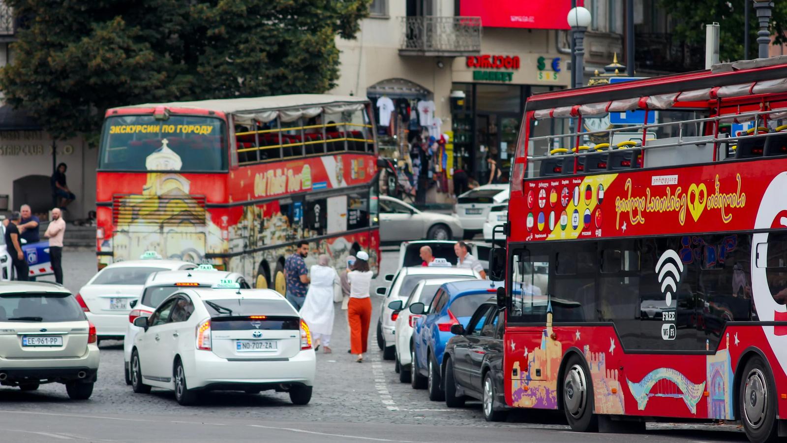 a double decker bus and cars on a busy street