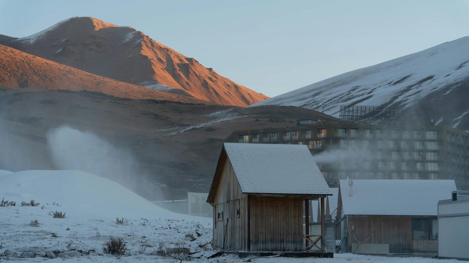 a small cabin in the middle of a snowy field