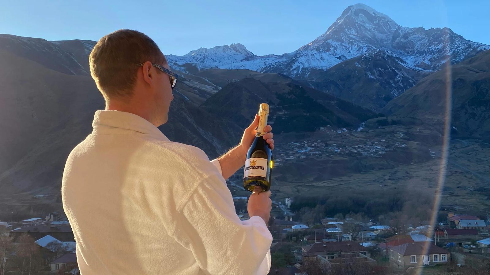 man in white long sleeve shirt holding black smartphone