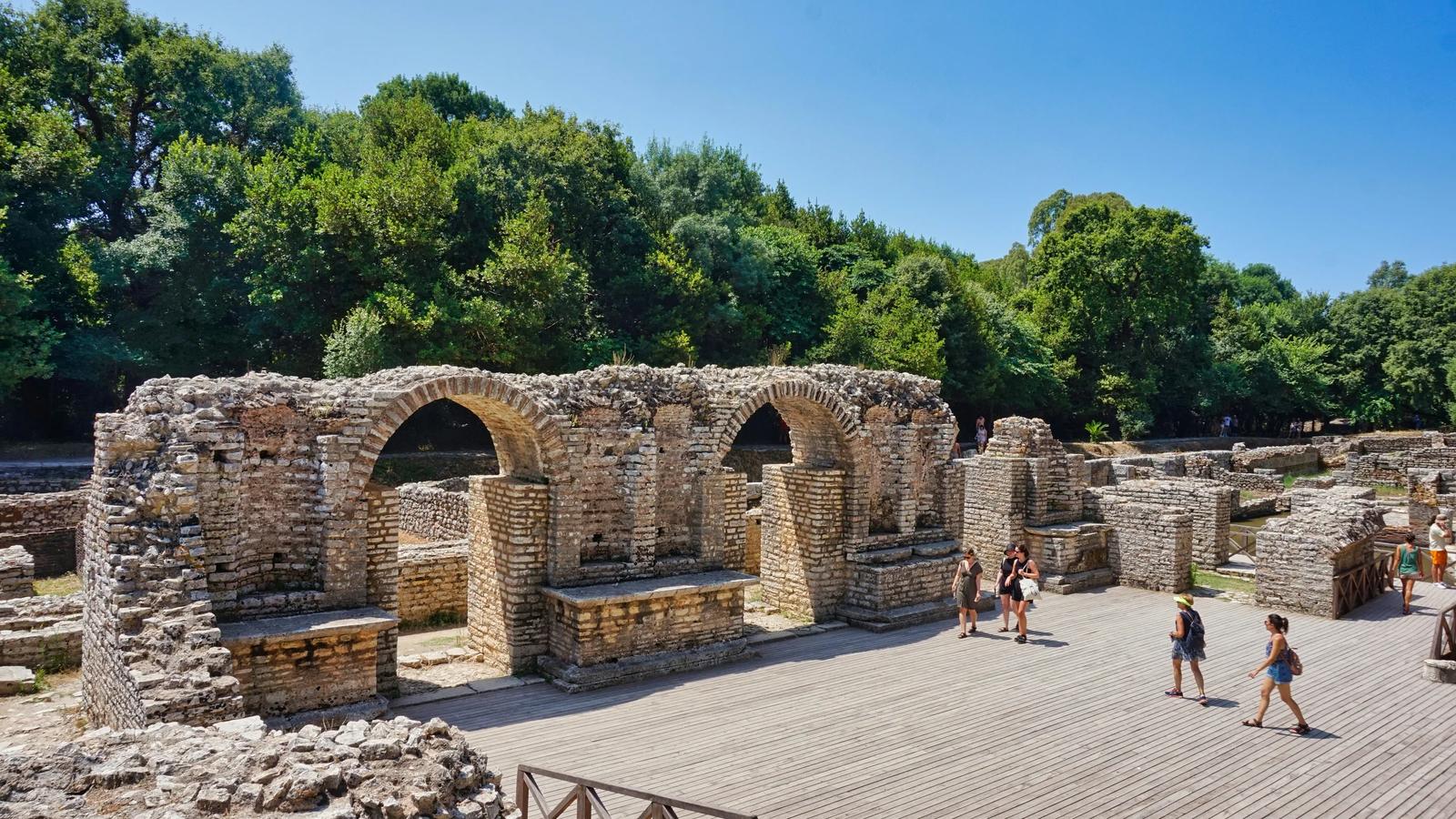 Ruins of an ancient building with some visitors.
