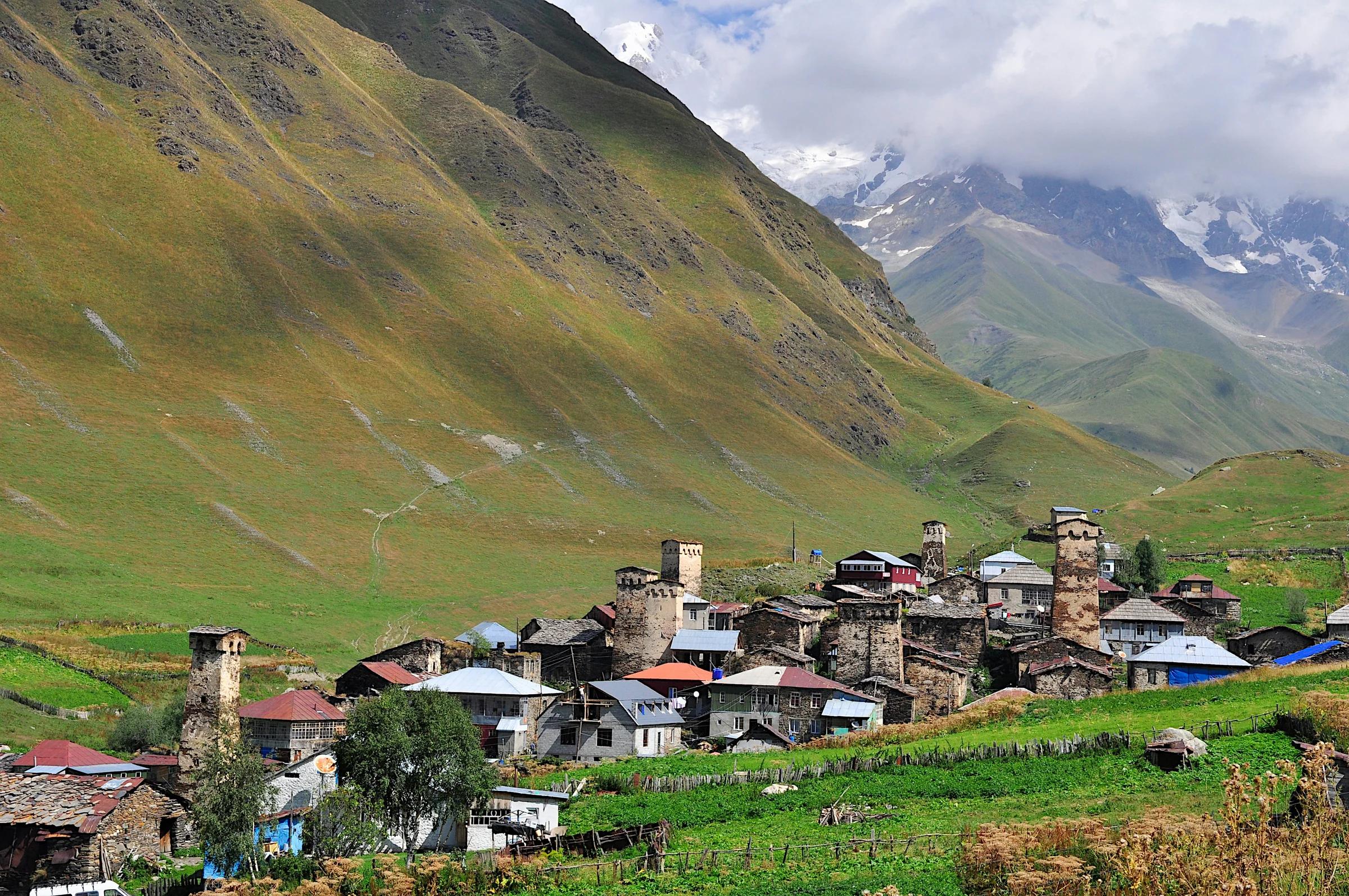a village in the mountains with a mountain in the background