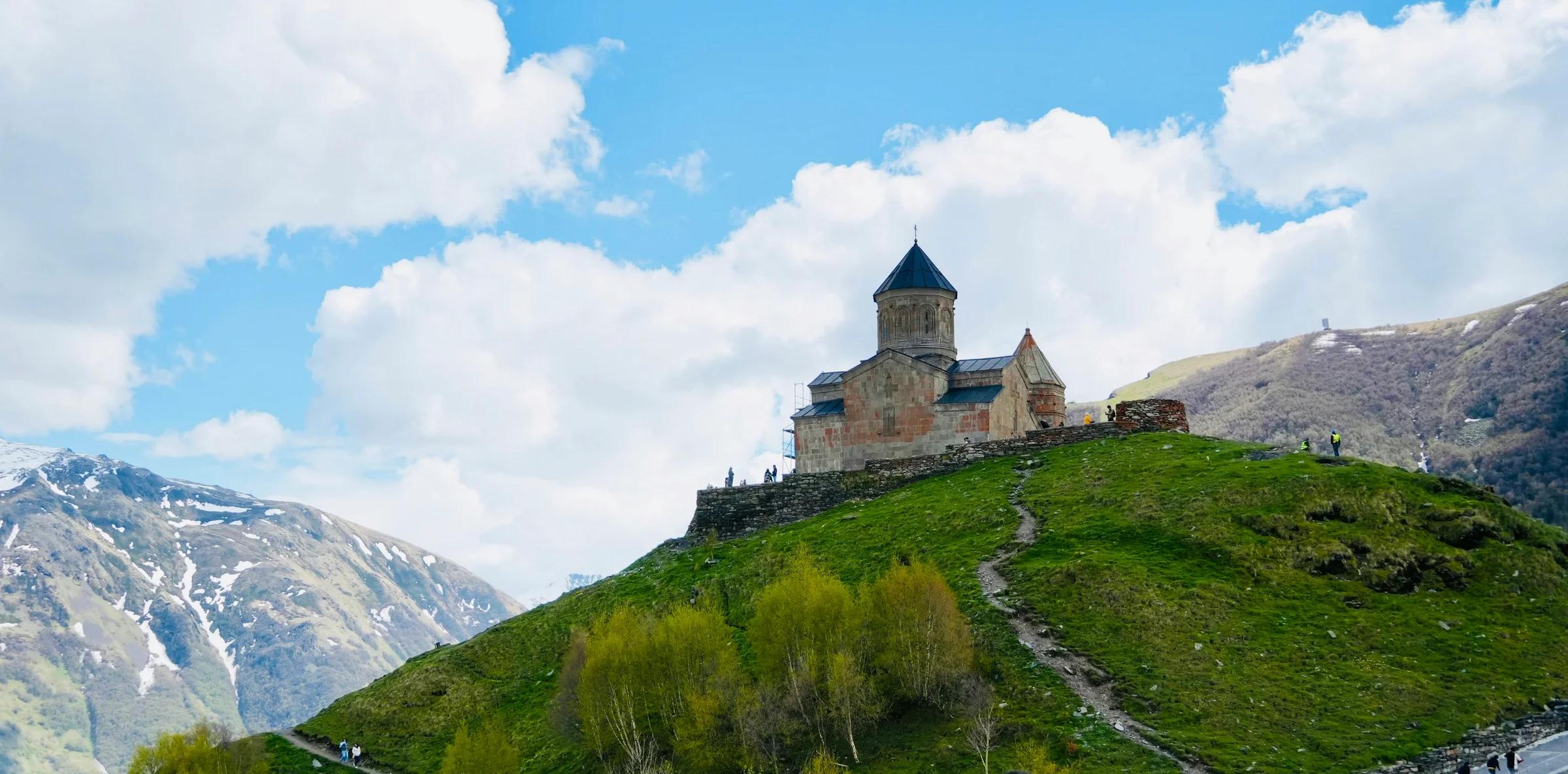 a castle sitting on top of a lush green hillside