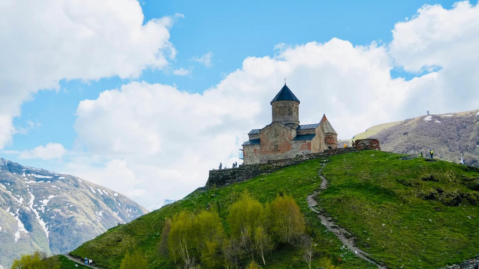 a castle sitting on top of a lush green hillside