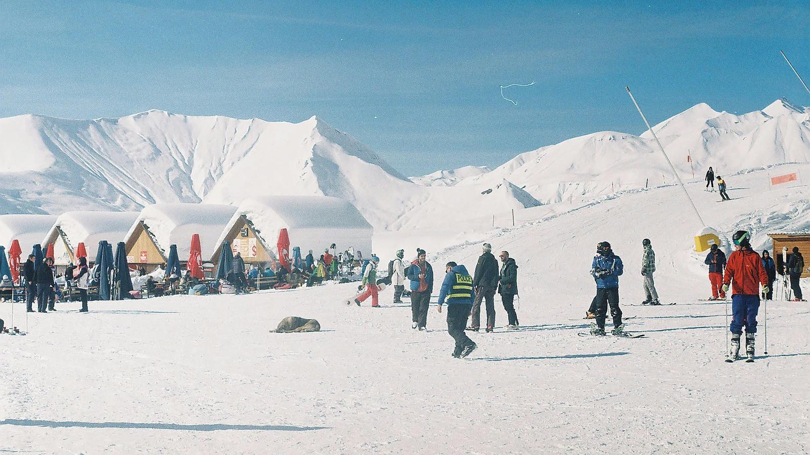 a group of people standing on top of a snow covered slope