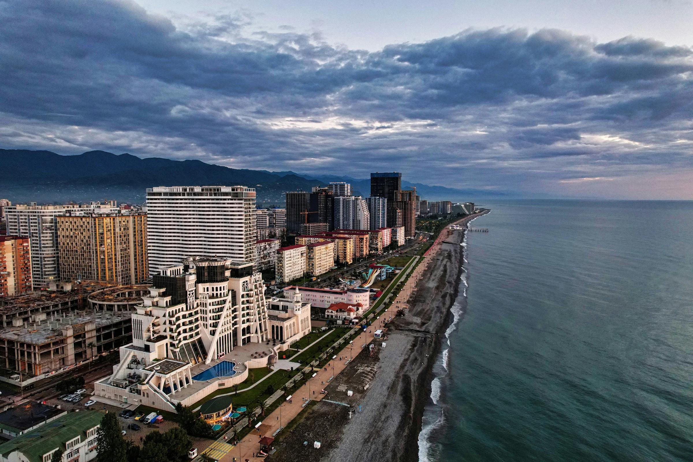 city skyline near body of water under cloudy sky during daytime