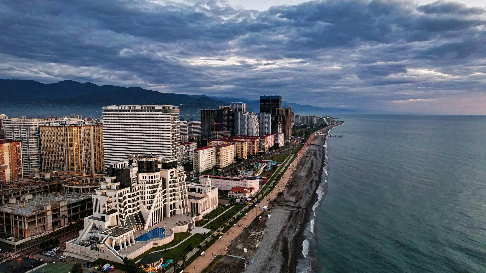 city skyline near body of water under cloudy sky during daytime