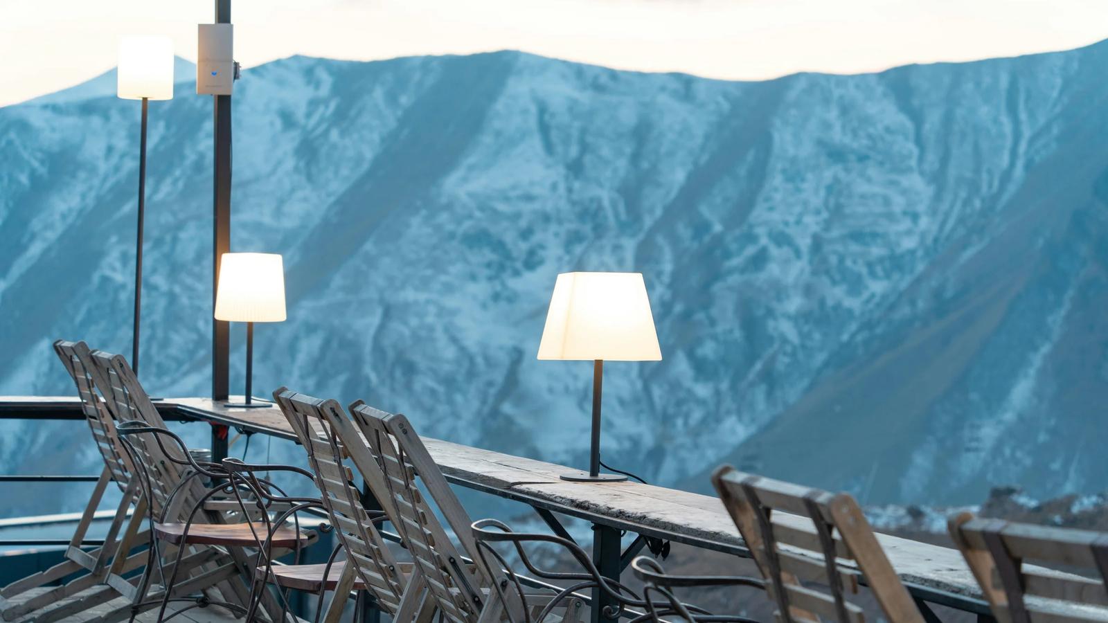 a table with chairs and lamps on top of a mountain