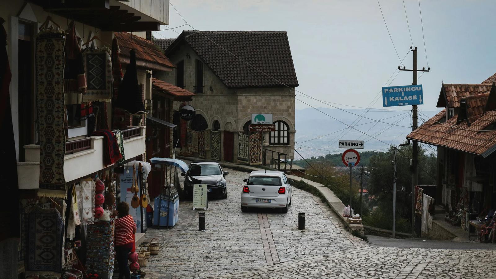 a car is parked on a cobblestone street