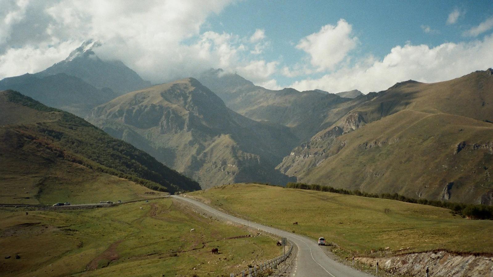 a scenic view of mountains and a road