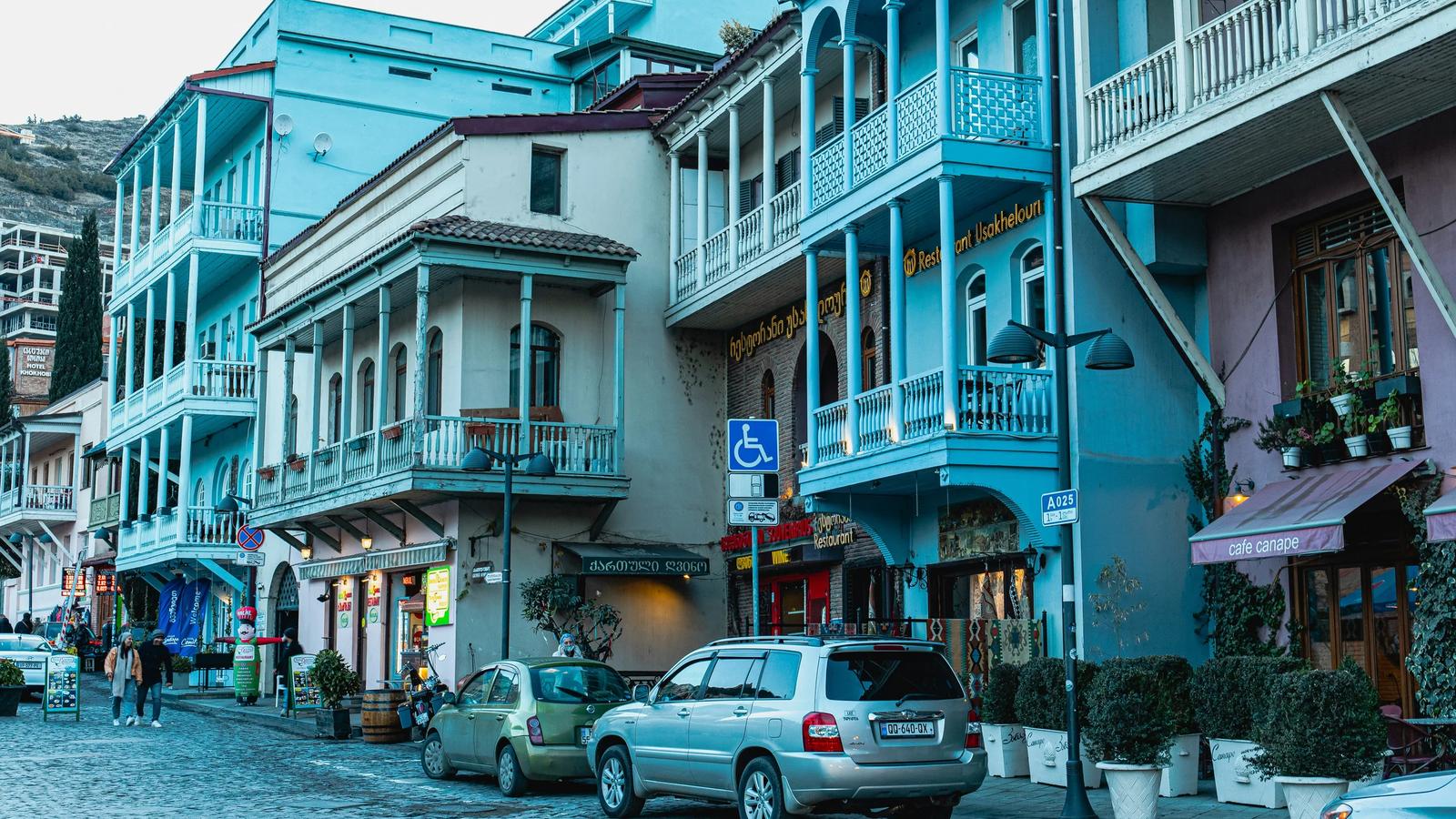 a row of buildings with cars parked on the side of the street