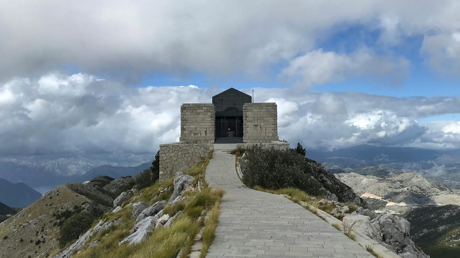 gray concrete building on top of hill under cloudy sky during daytime