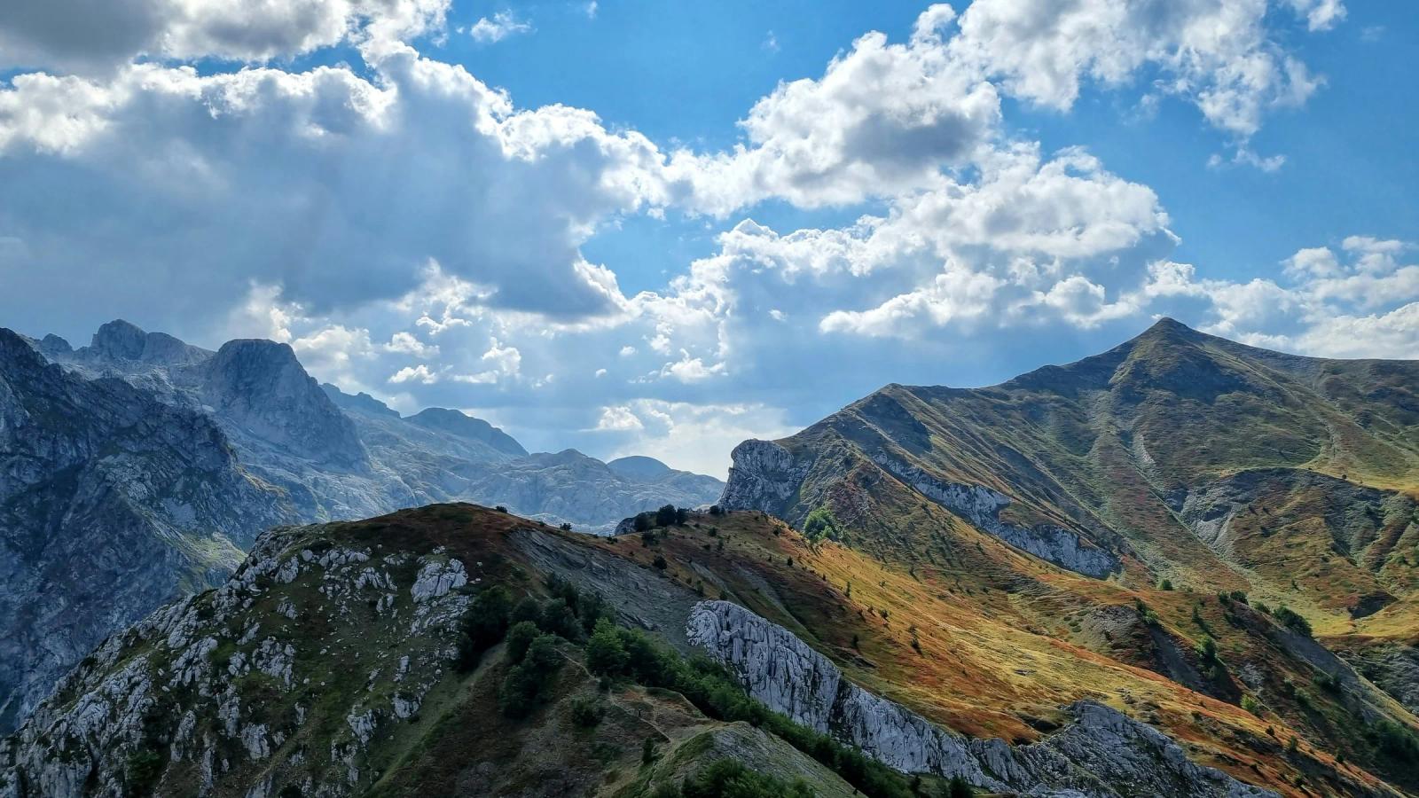 a view of a mountain range with clouds in the sky