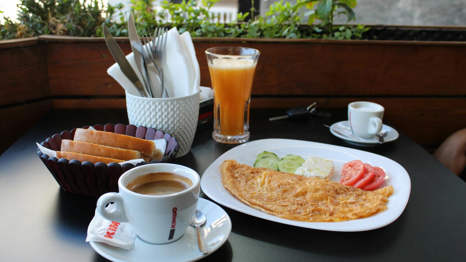 A table topped with a plate of food and a cup of coffee