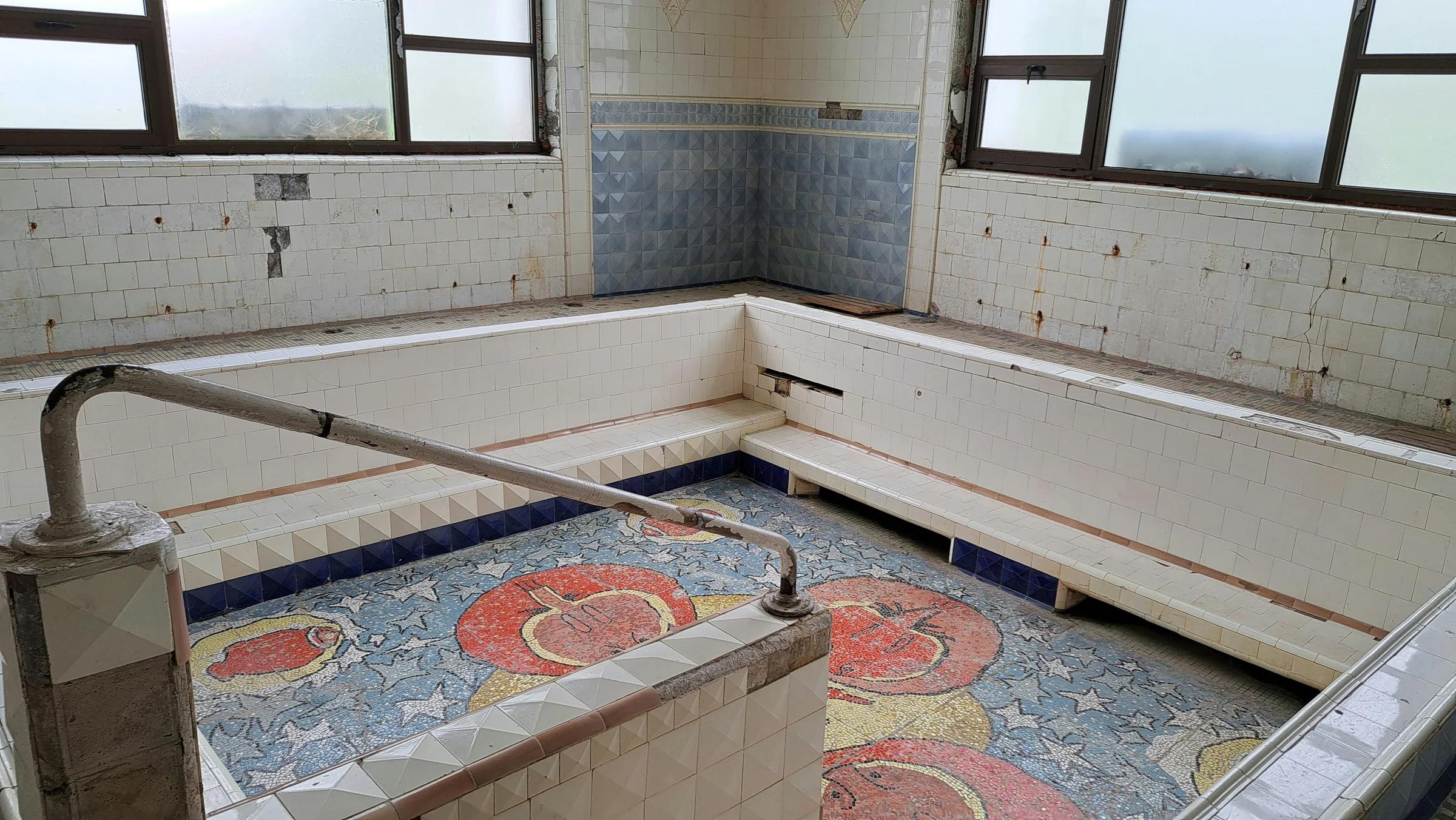 A bath room with a tiled floor and windows