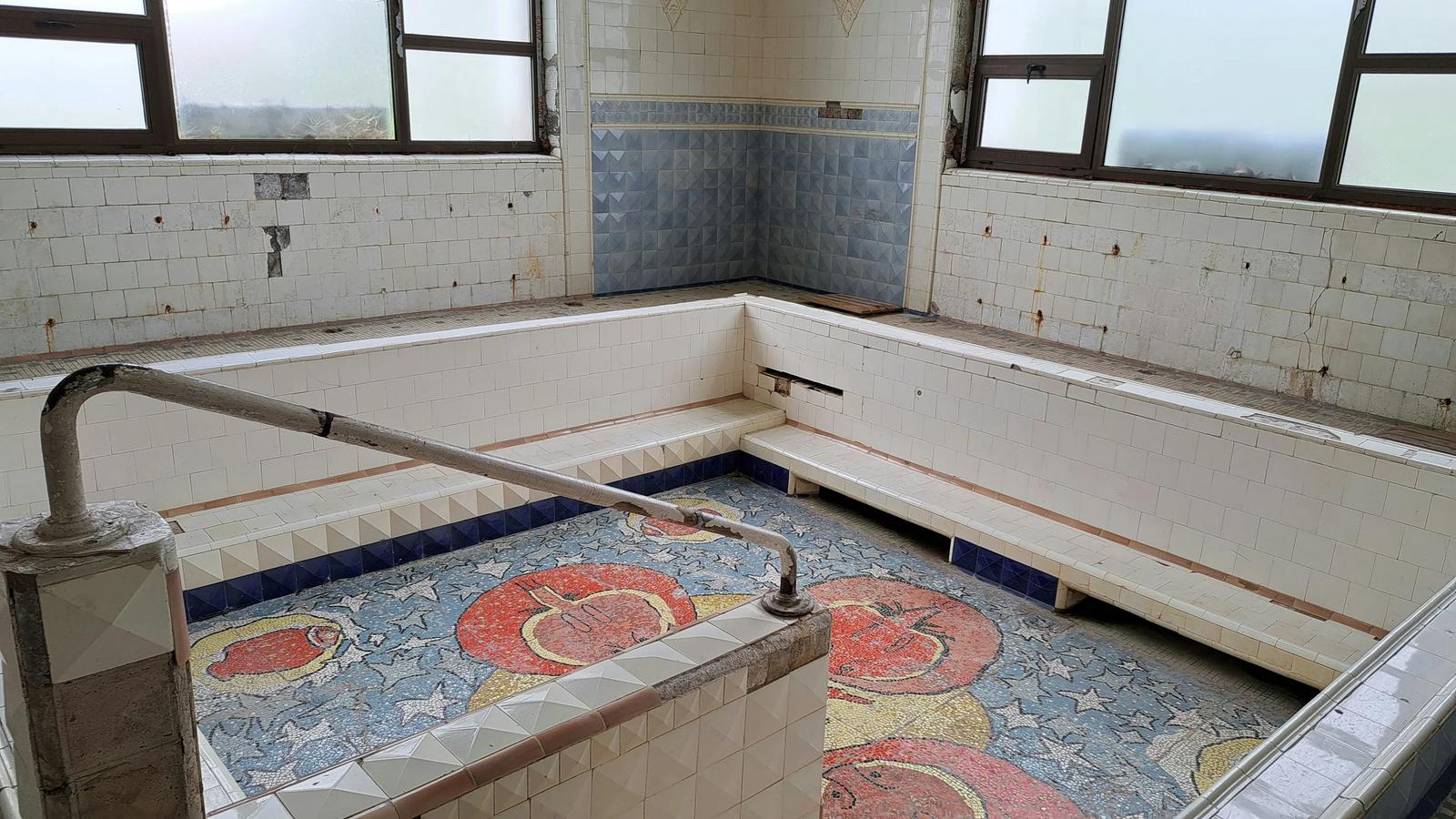 A bath room with a tiled floor and windows