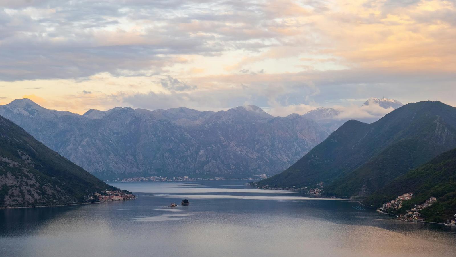 body of water near mountain during daytime