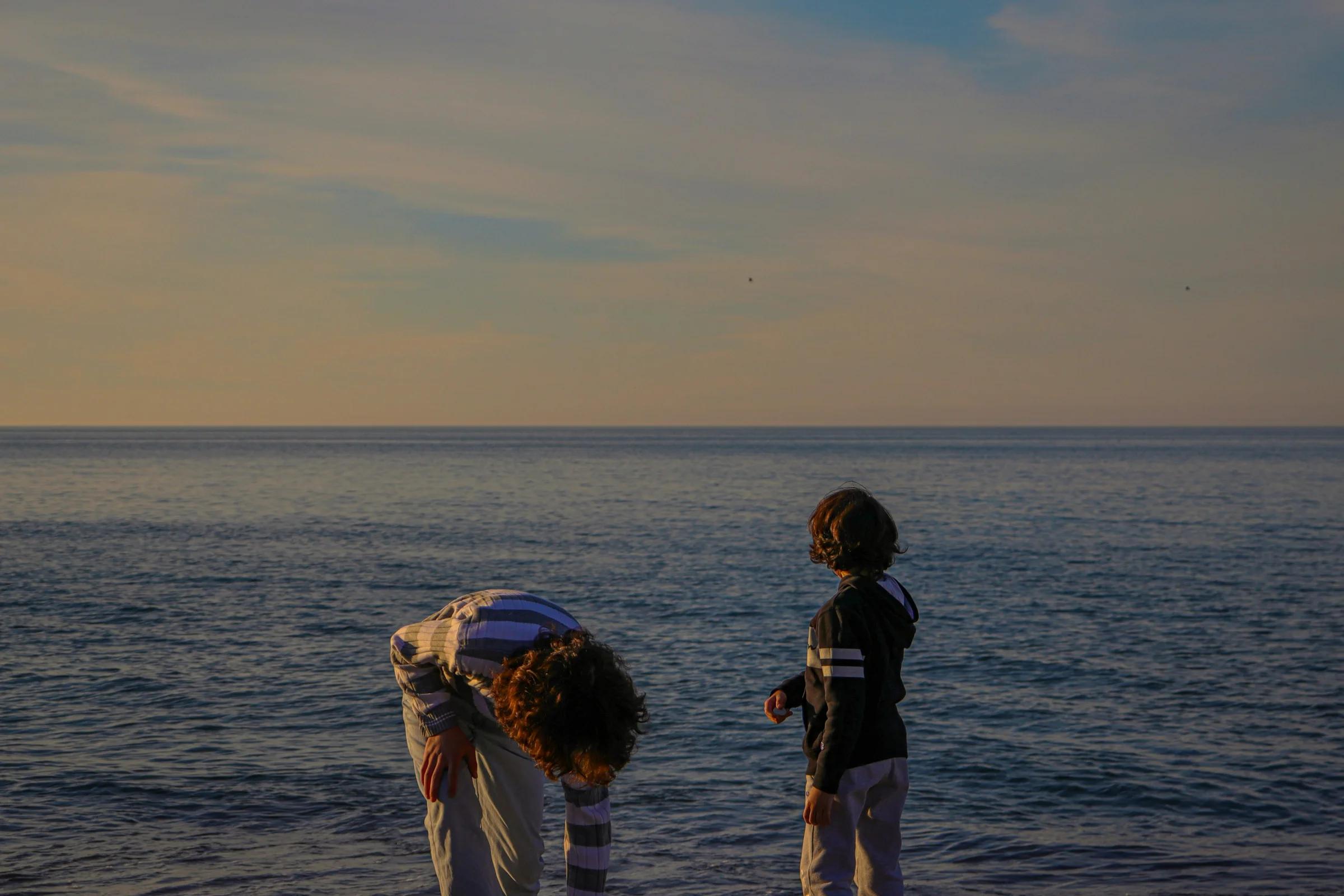A couple of people standing on top of a beach