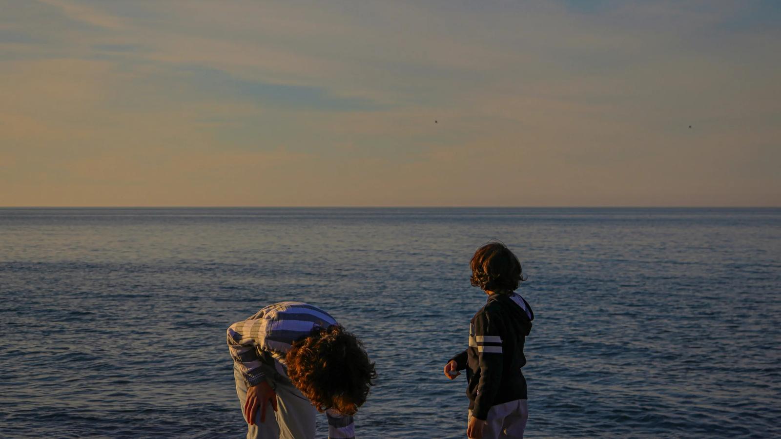 A couple of people standing on top of a beach