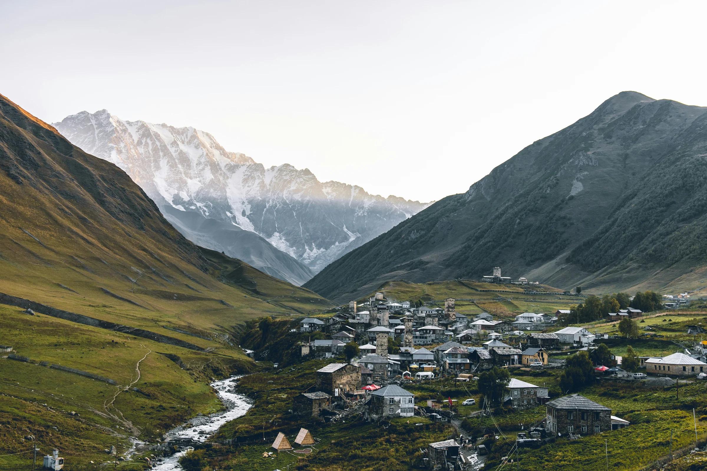 aerial photography of houses beside rocky mountains during daytime