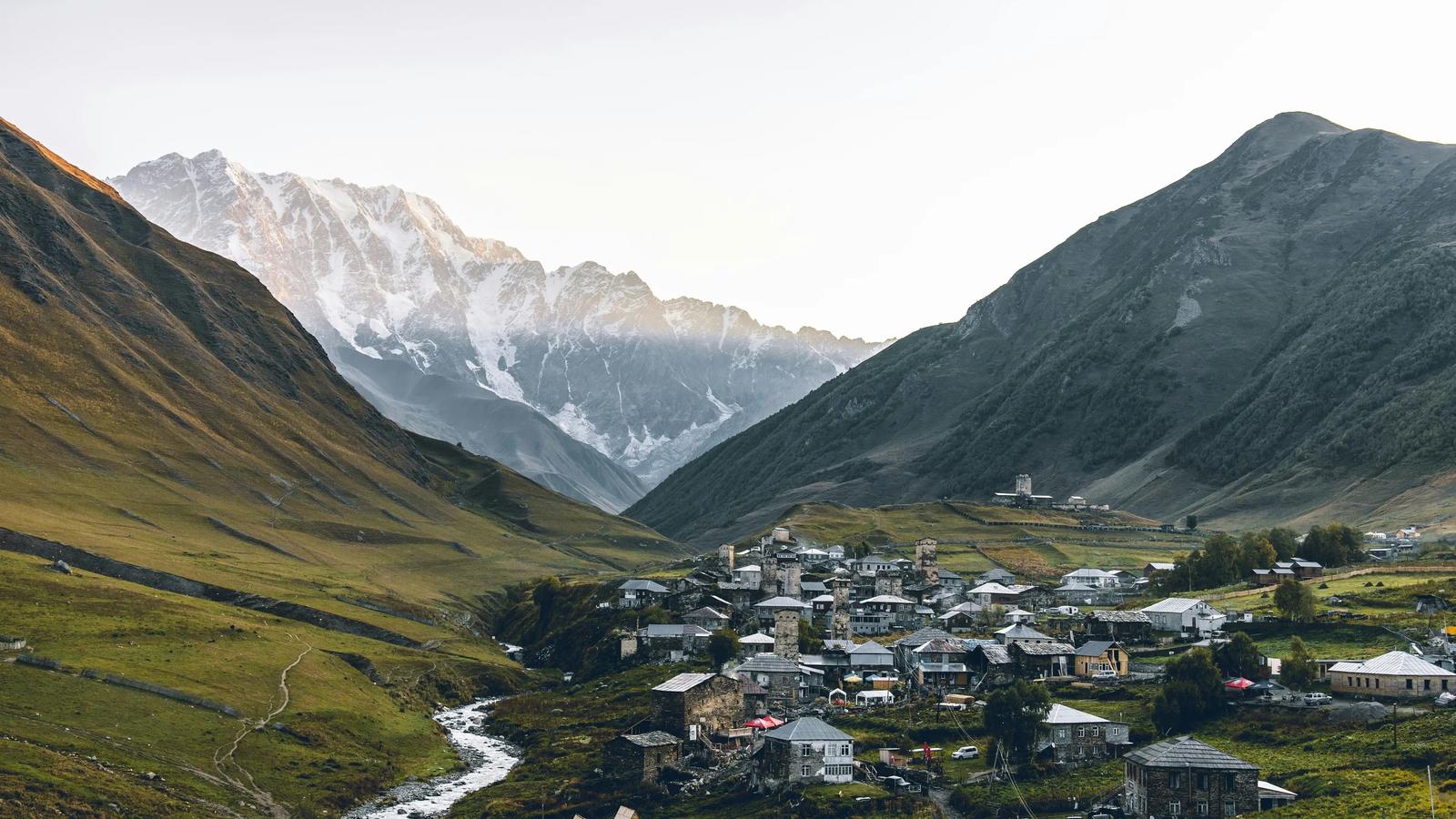 aerial photography of houses beside rocky mountains during daytime