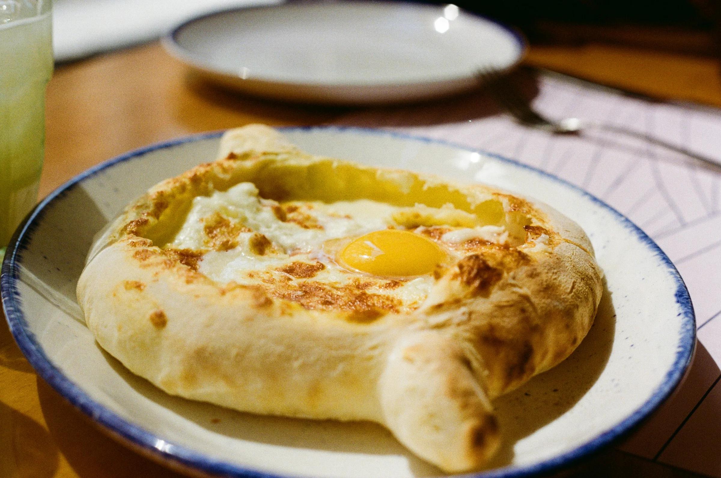Khachapuri, a georgian bread dish, sits on a plate.