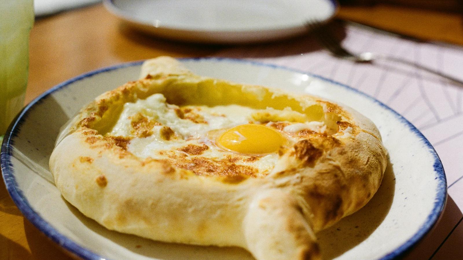 Khachapuri, a georgian bread dish, sits on a plate.