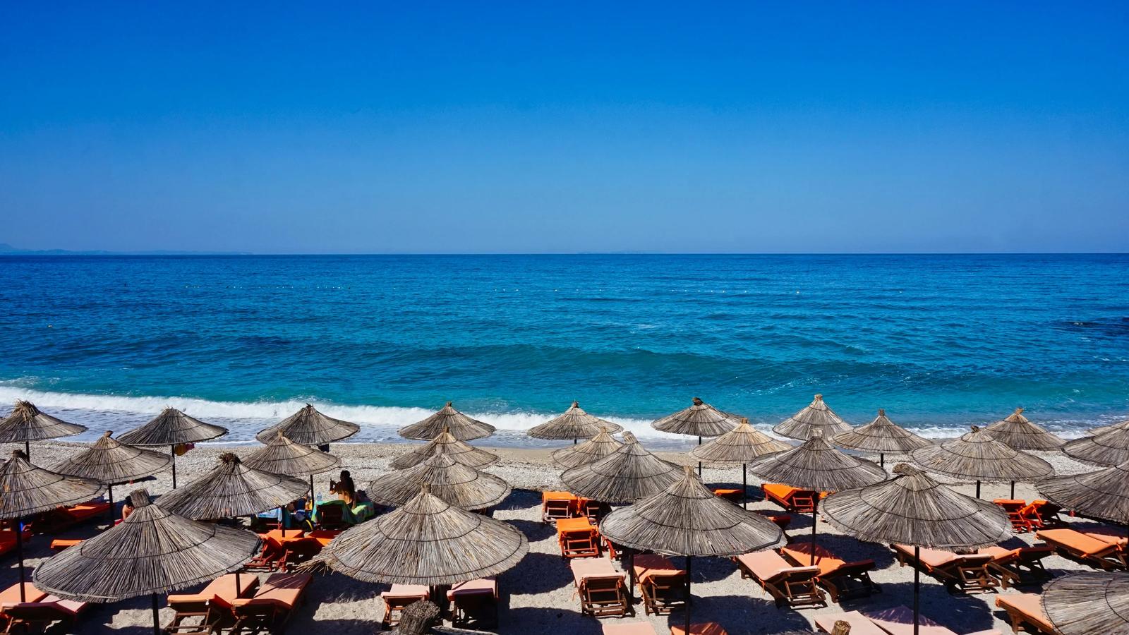A bunch of umbrellas that are on a beach