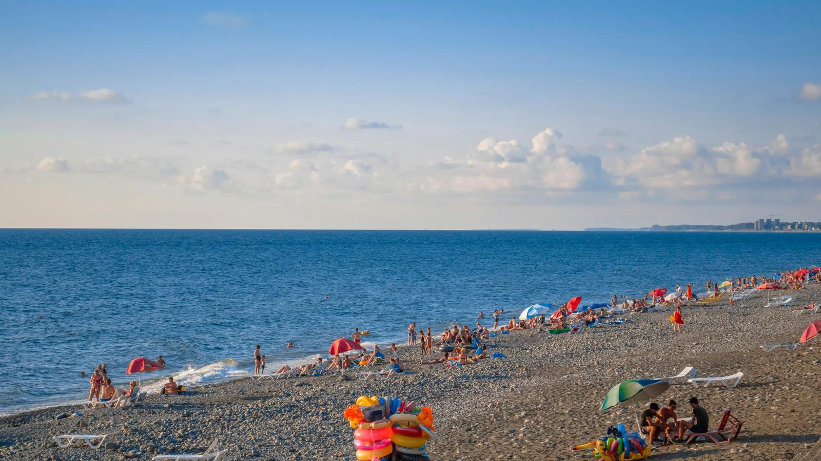a beach filled with lots of people and umbrellas