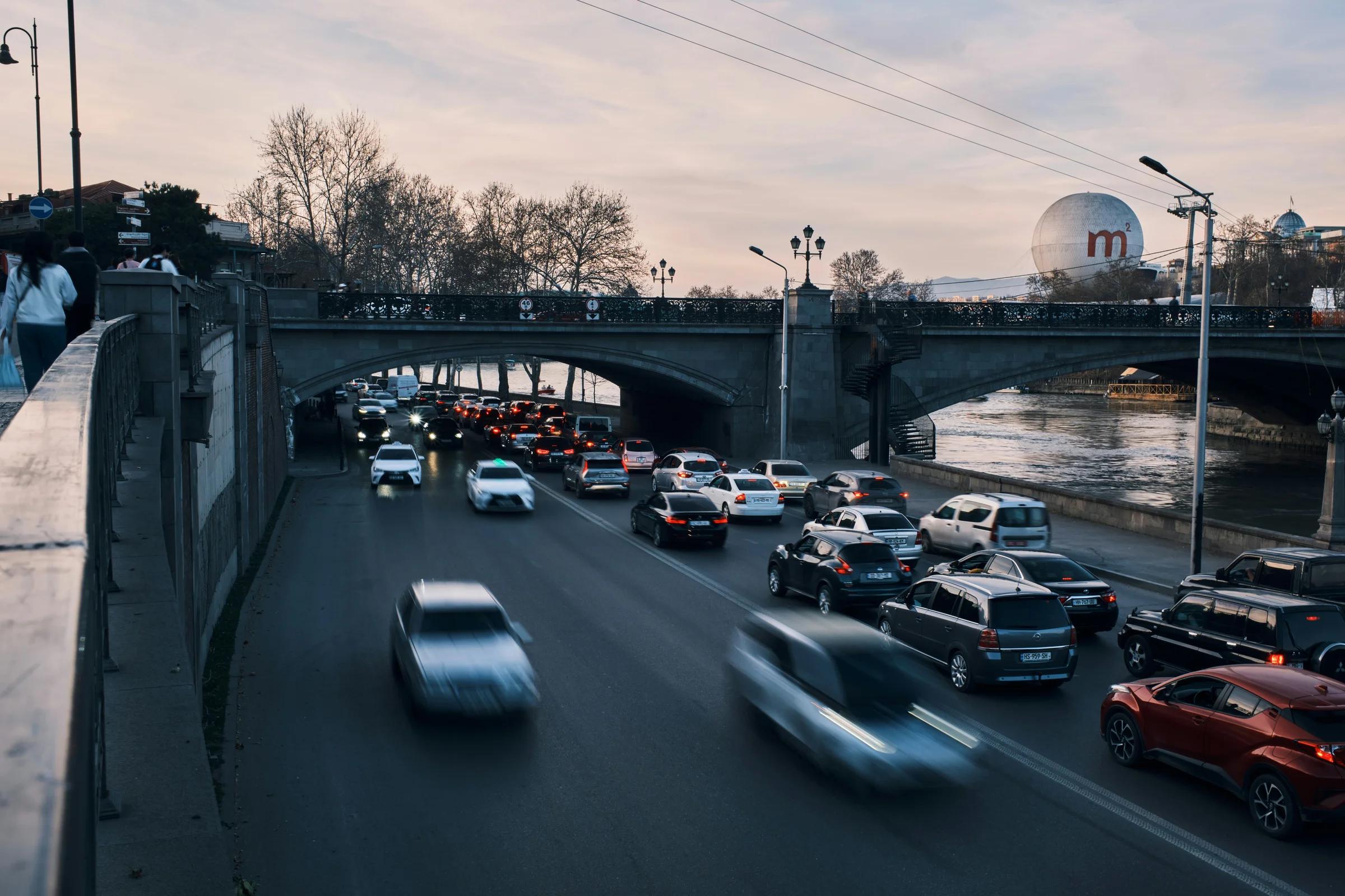 Cars drive on a bridge over the water.