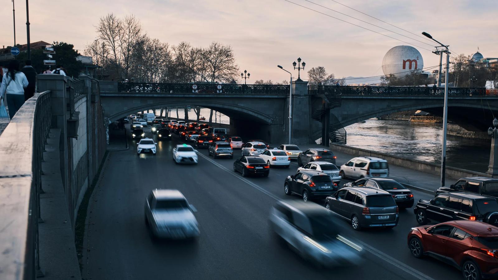 Cars drive on a bridge over the water.