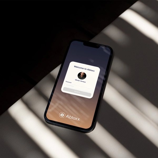 Photo of a phone screen showing an Abloxx login page for a sample user. Large text at the top of the image reads ‘What’s coming next?’