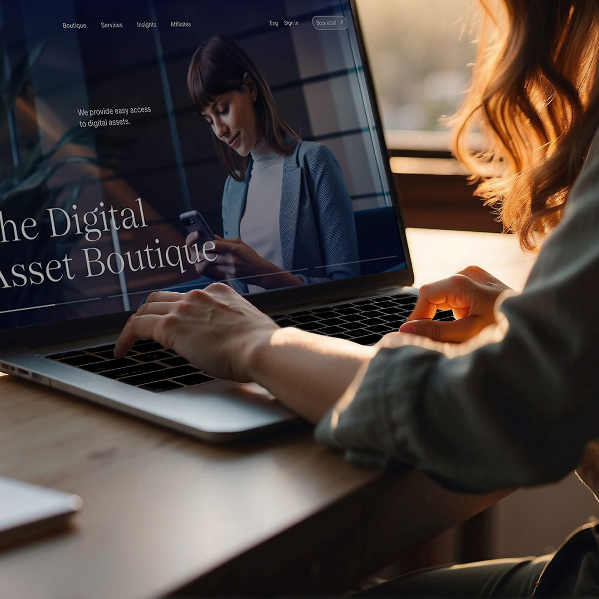 Photo of a person’s hands typing on a slick laptop. The bottom of the screen displays the text ‘The Digital Asset Boutique’ against a blue background.