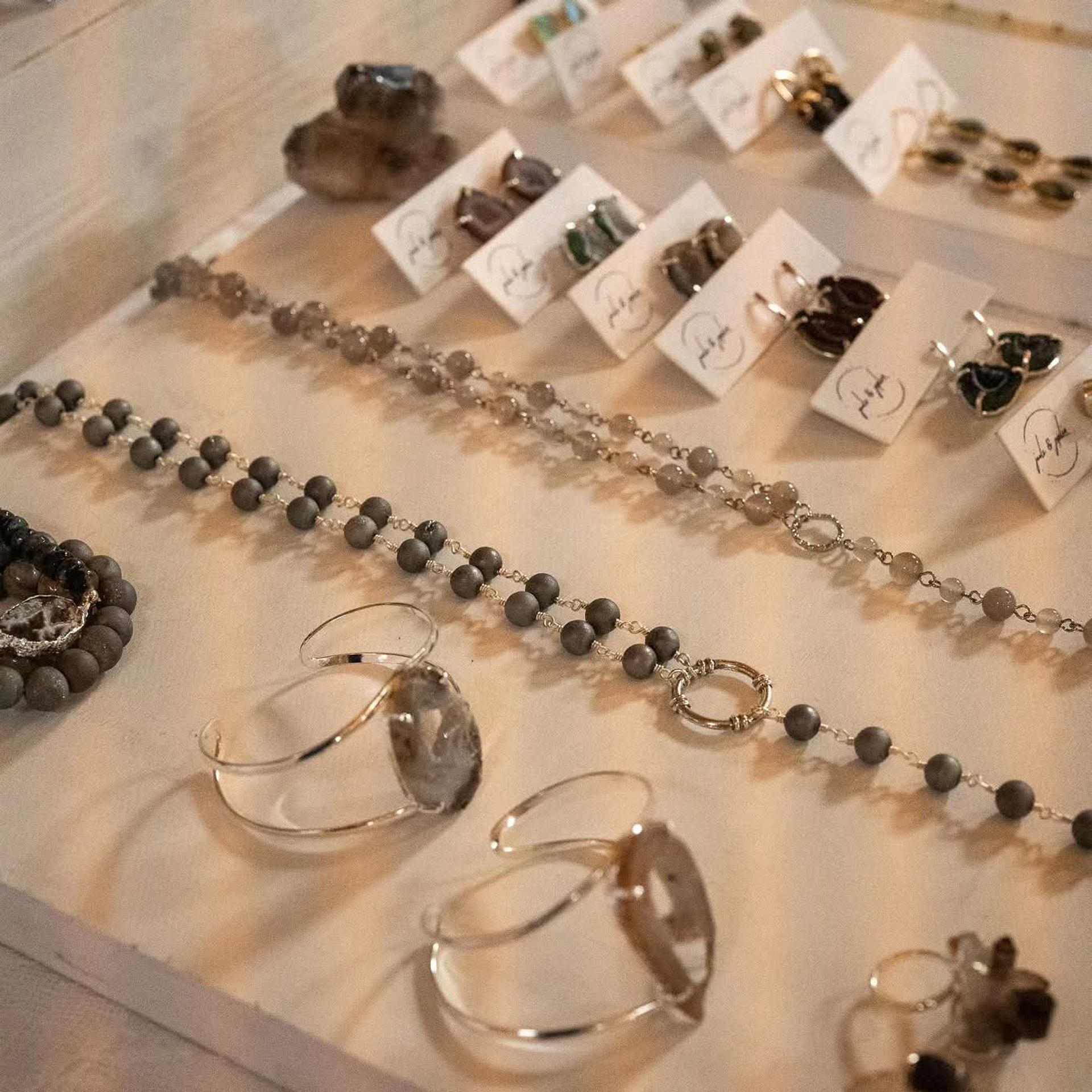 Display case with neatly arranged bracelets, necklaces, and earrings.