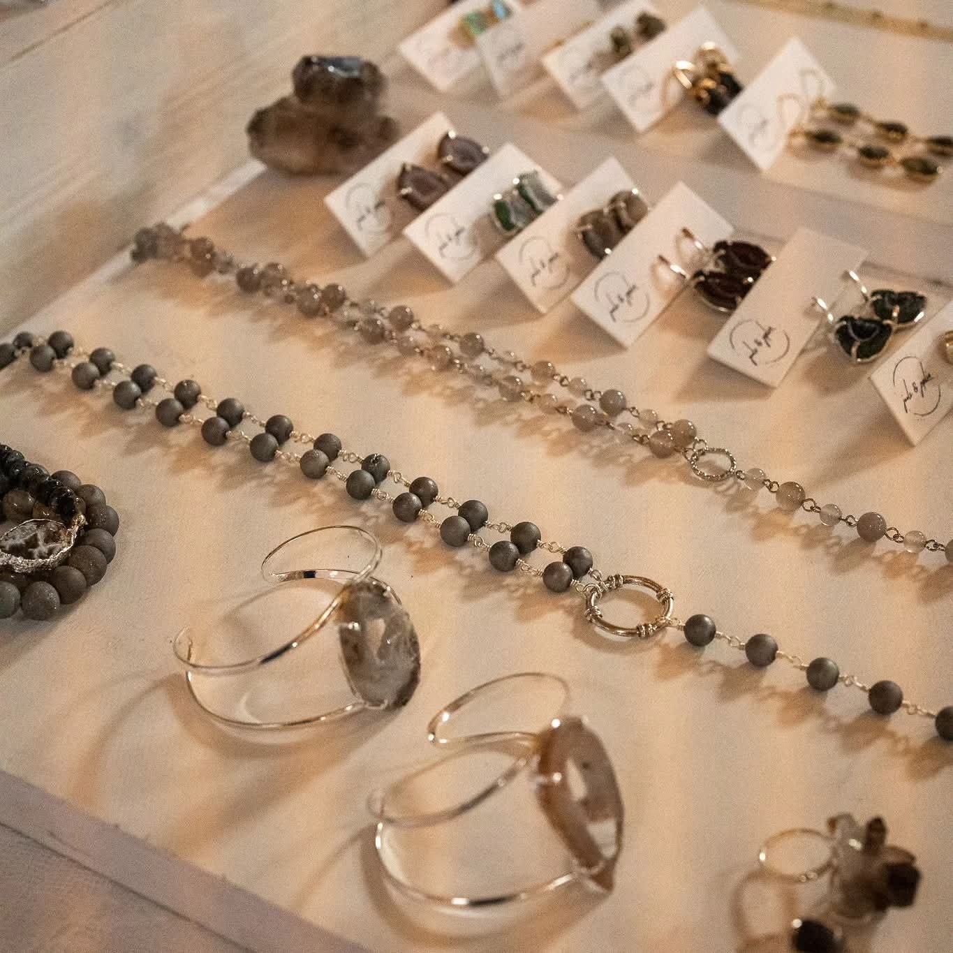 Display case with neatly arranged bracelets, necklaces, and earrings.