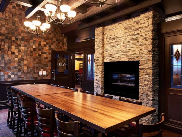 Elegant dining room with fireplace, chandeliers, and stained glass windows.