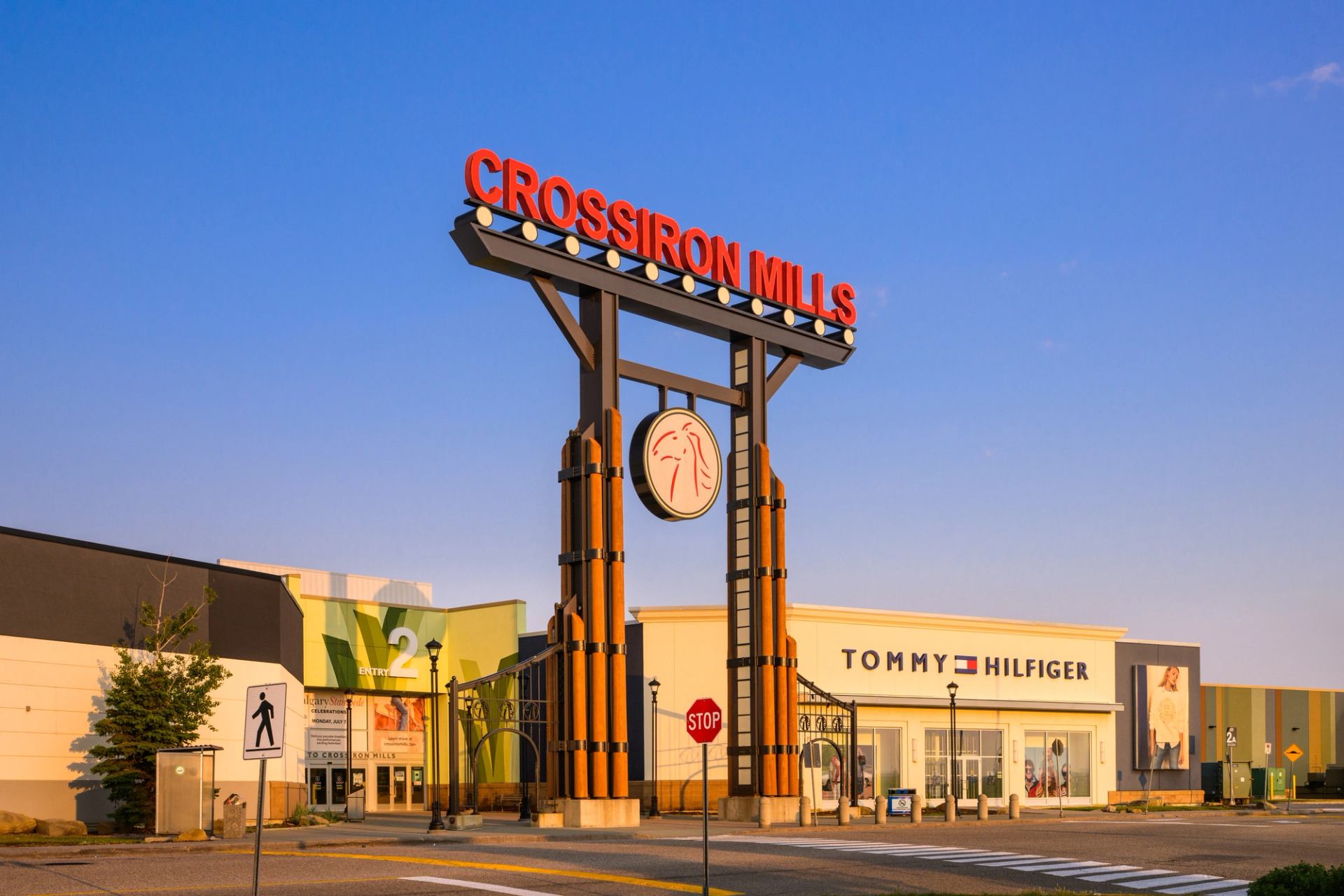 Exterior of CrossIron Mills mall with store signs and clear sky.