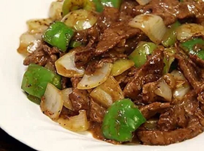 Beef stir-fry with green peppers and onions in a savory brown sauce.