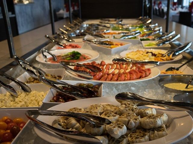 Salad bar at Pampa Brazilian Steakhouse featuring meats, cheeses, vegetables, and chilled dishes.