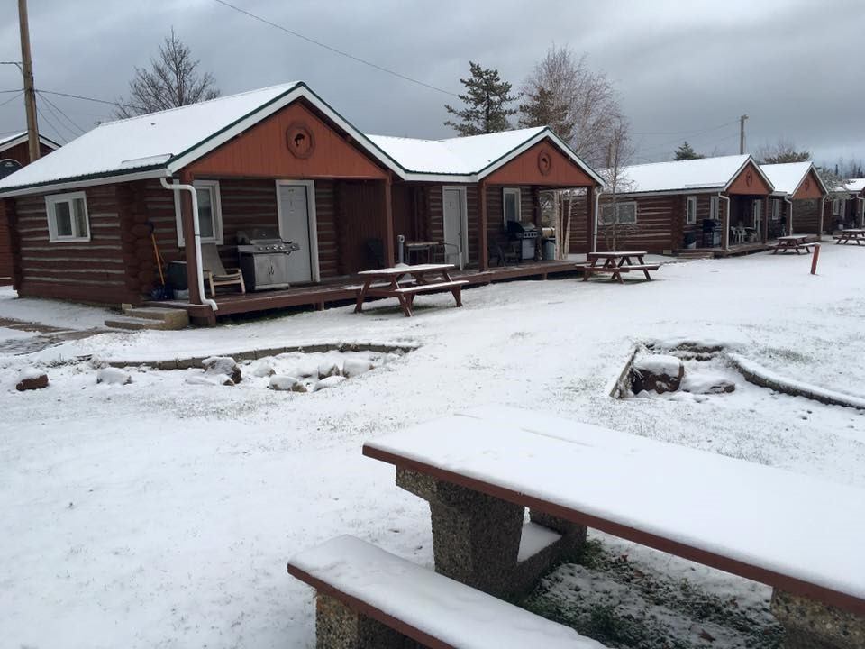 Cozy dining area with wooden tables, chairs, and Canadian flags inside Christina Lake Lodge.