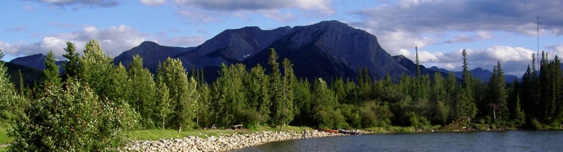 A beautiful view of the lake with the trees and mountains in the background