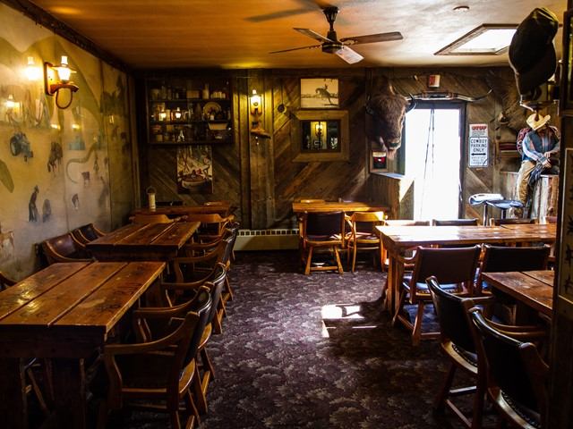 Rustic dinning room with long tables and chairs.
